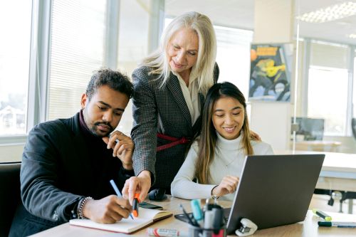 An adult team collaborating in an office environment, focusing on teamwork and diversity.